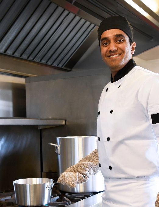 smiling chef cooking at stove