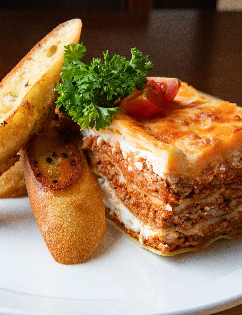 plate of lasgna served with french bread loaf