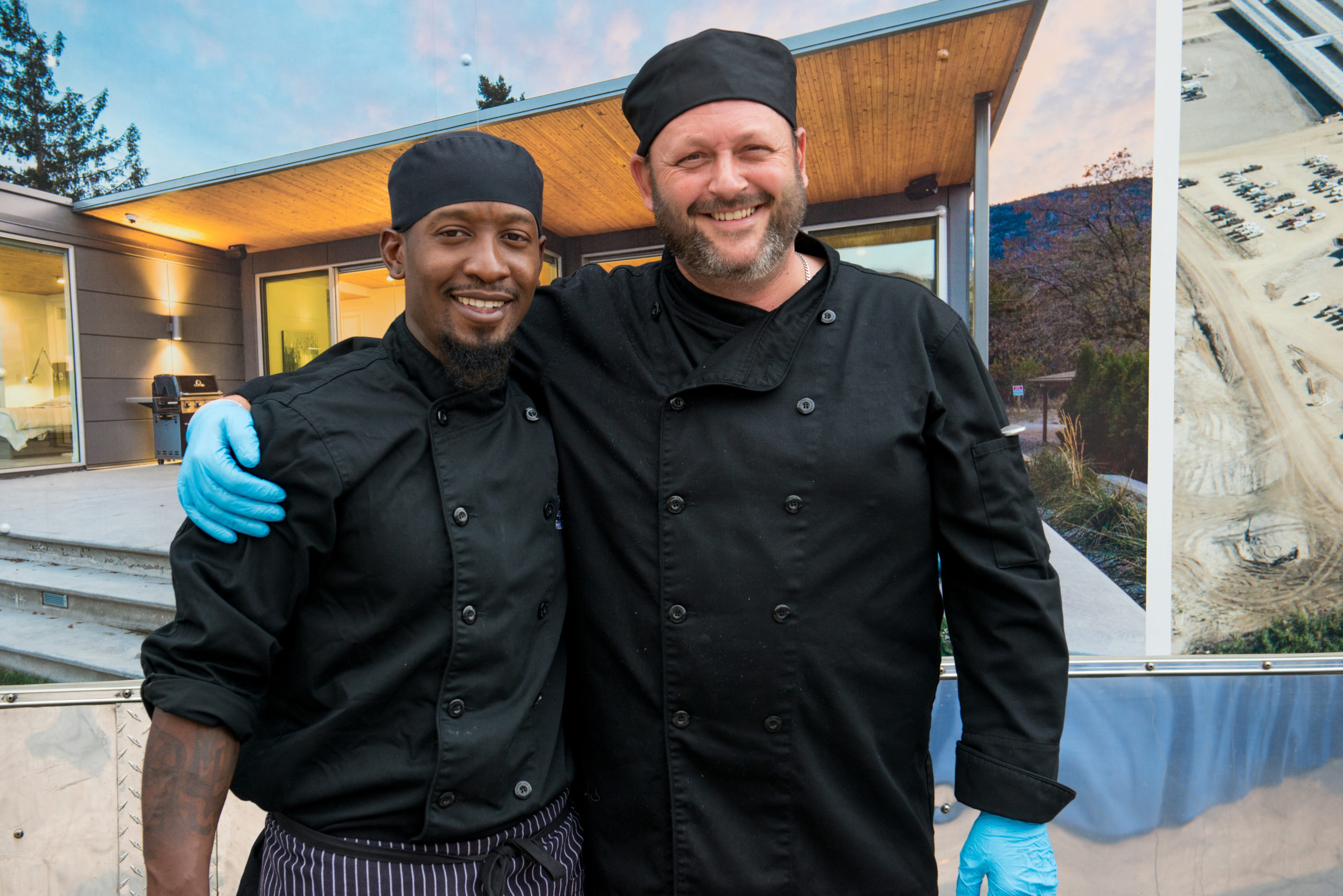 two men in chef uniform with arms around each other