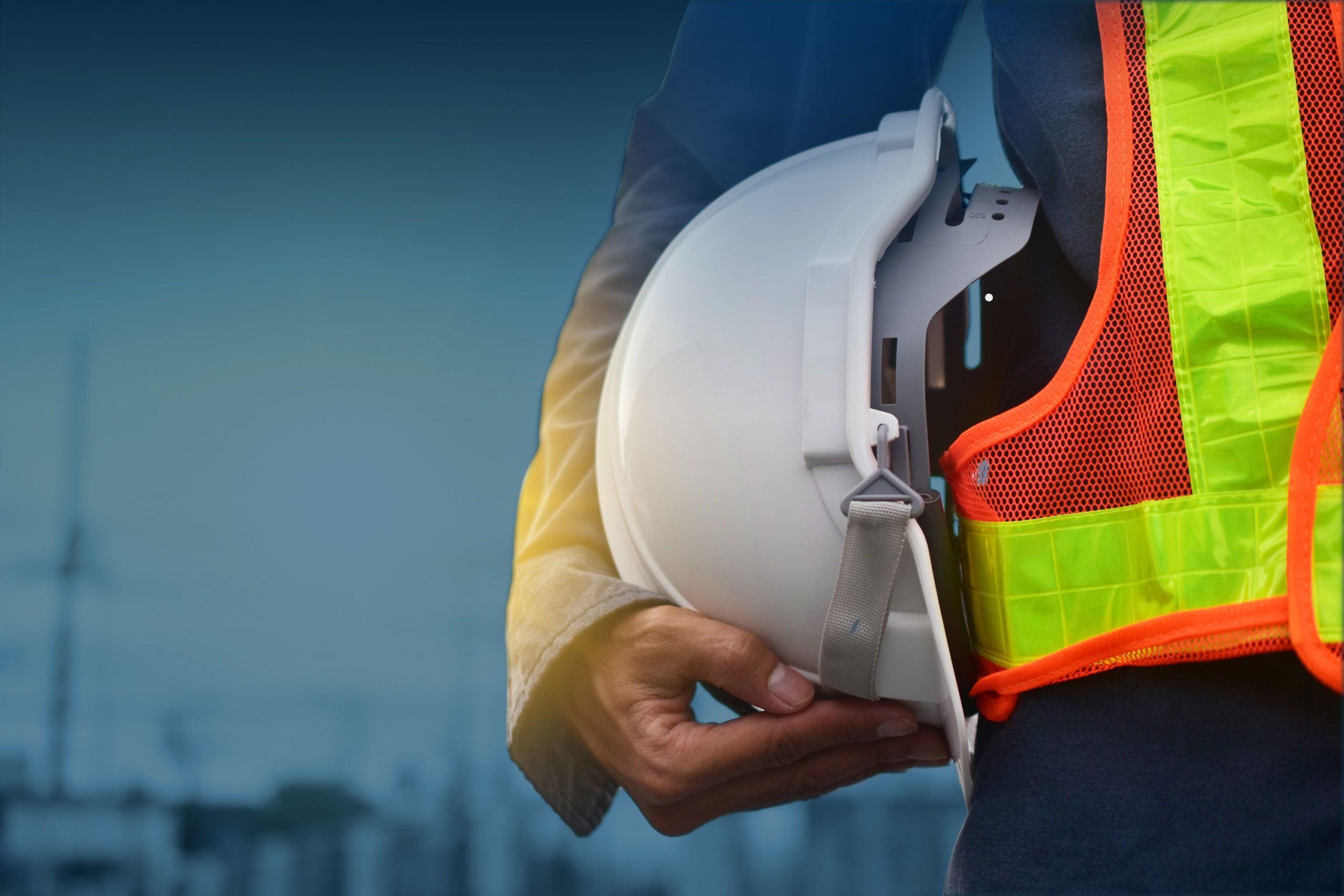 Man in construction vest holding safety helmet
