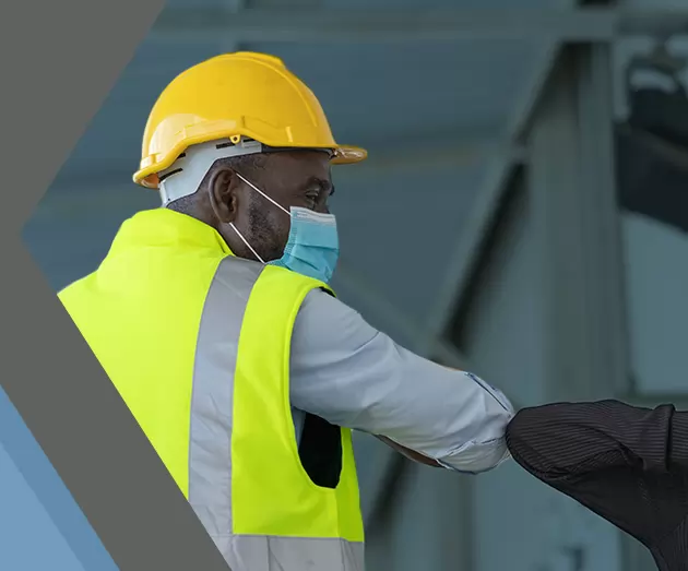 man and woman in hard hats touching elbows