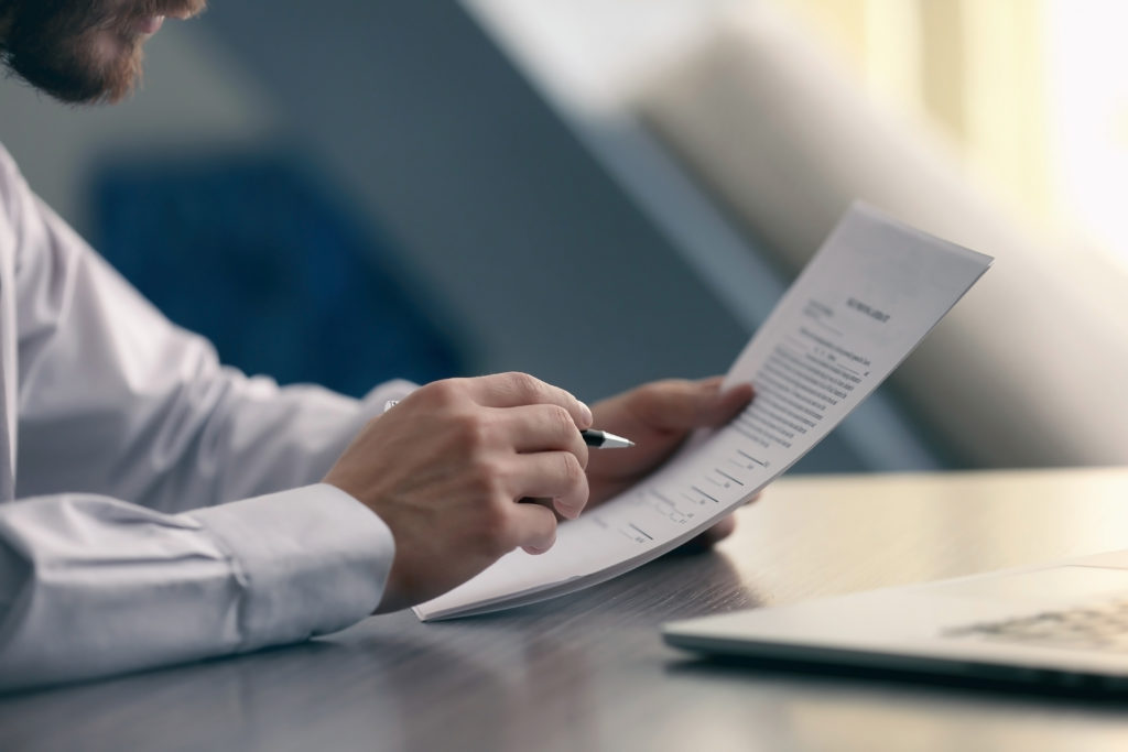 person holding papers and a pen