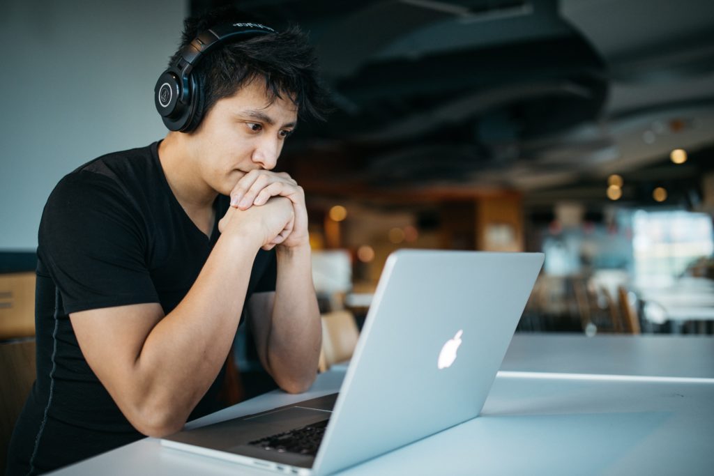 Man stares intently at laptop.