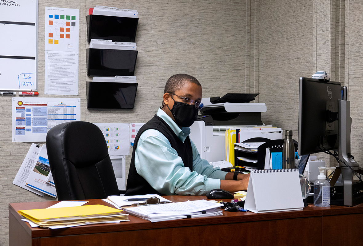 man in office working at desk with mask