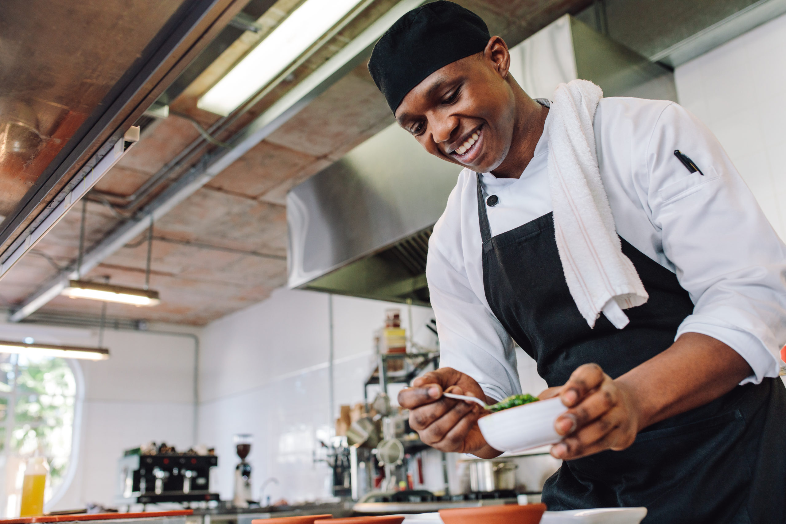 man in chefs outfit preparing a meal in the kitchen