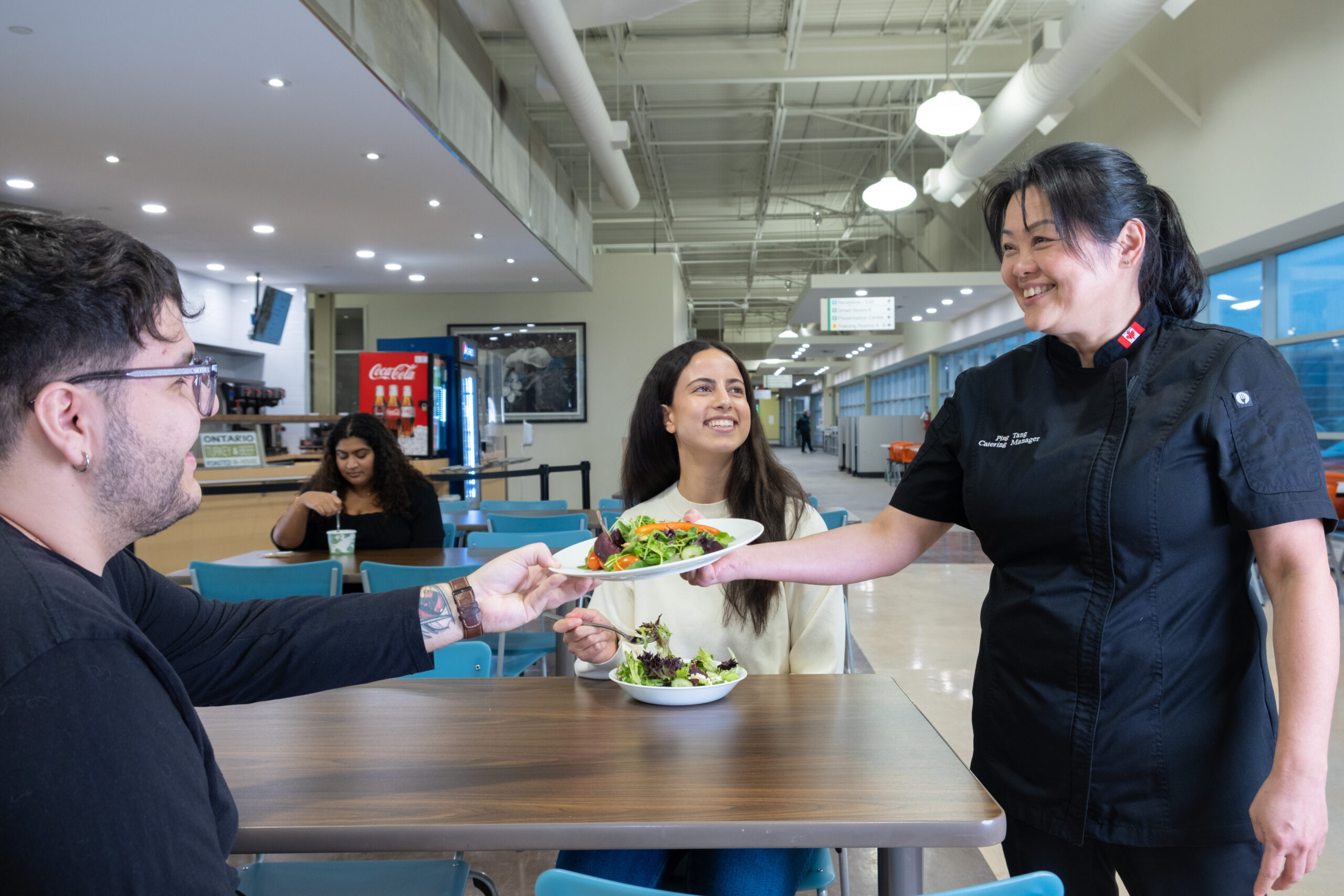 woman serving a plate of salad to a customer